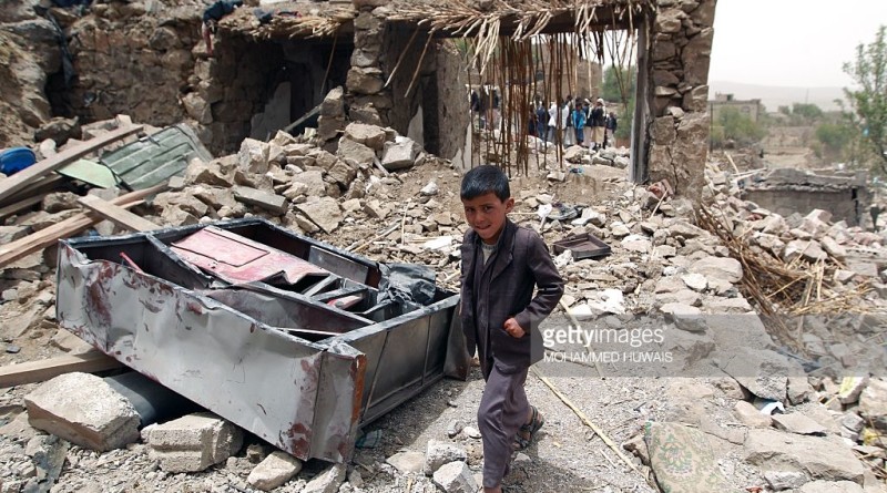 A Yemeni boy walks past the rubble of destroyed houses in the village of Bani Matar, 70 kilometers (43 miles) West of Sanaa, on April 4, 2015, a day after it was reportedly hit by an airstrike by the Saudi-led coalition against Shiite Huthi rebel positions. A Saudi-led coalition pounded rebels in southern Yemen and dropped more arms to loyalist fighters as the UN Security Council prepared to discuss calls for 'humanitarian pauses' in the air war. AFP PHOTO / MOHAMMED HUWAIS